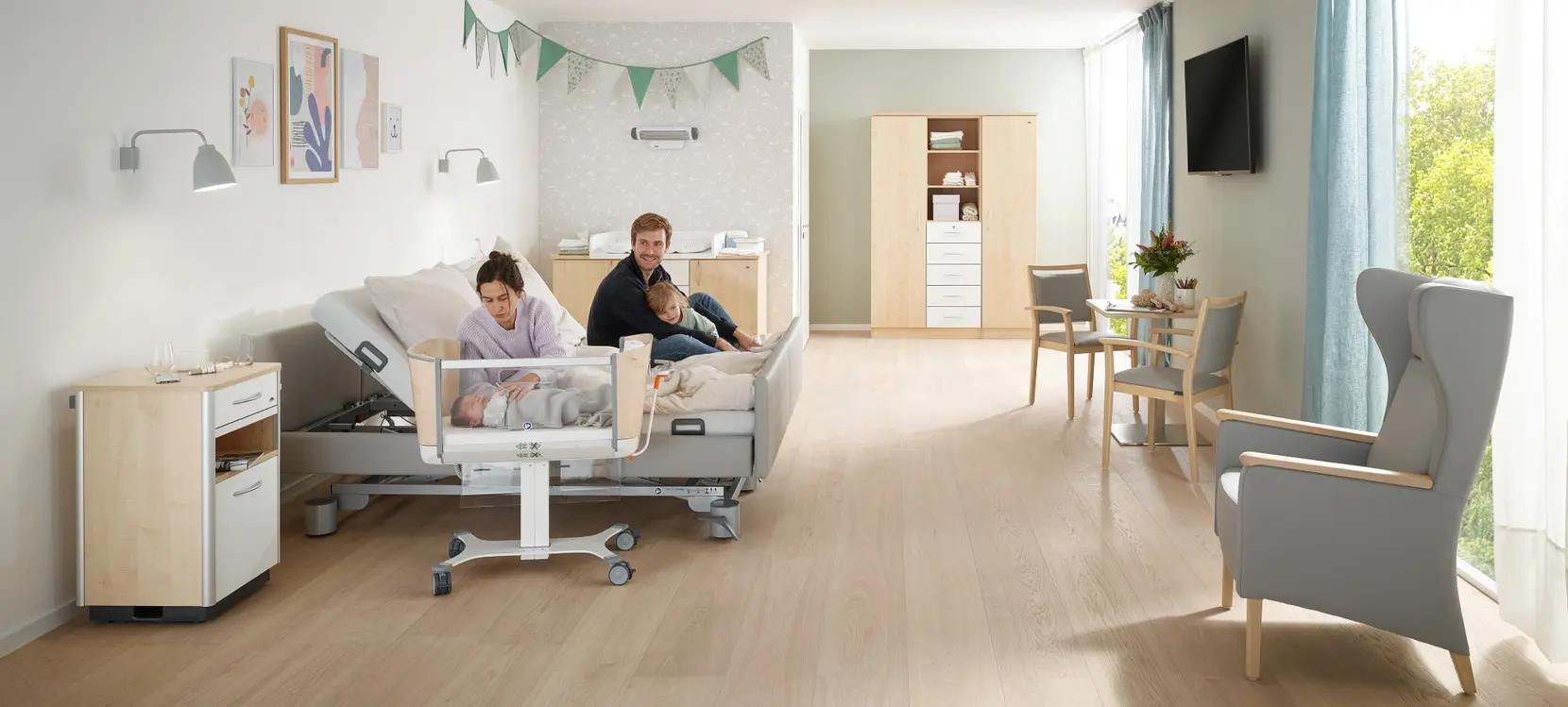 Family room in hospital with partner bed and Jovie baby cot from Stiegelmeyer Modern family room in hospital with a double bed for parents, Jovie baby cot and homelike comfort, where parents and newborns can spend time together.