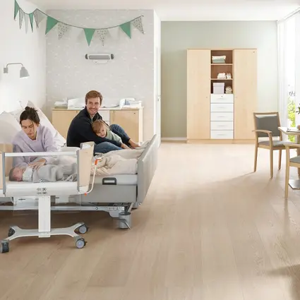 Family room in hospital with partner bed and Jovie baby cot from Stiegelmeyer Modern family room in hospital with a double bed for parents, Jovie baby cot and homelike comfort, where parents and newborns can spend time together.