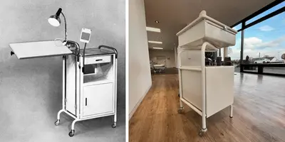 Historischer Krankenhaus-Nachttisch aus den 1950er-Jahren mit schräger Ablagefläche, Leselampe und Rollen.