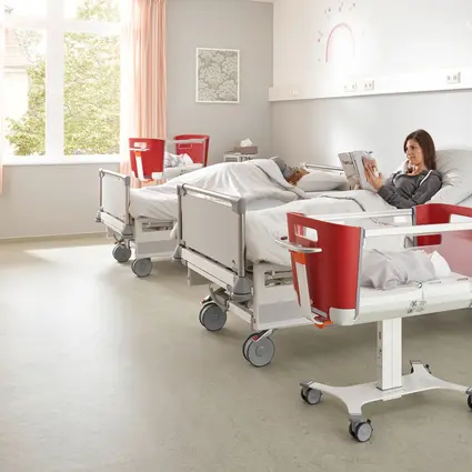 Modern patient room in the maternity ward with hospital beds and baby cot from Stiegelmeyer Bright patient room in a maternity ward with two modern hospital beds, a mobile baby cot and homelike comfort for mother and newborn.
