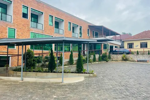 La entrada a la clínica Solace de la ciudad ruandesa de Kabuga está situada en una plaza pavimentada. Este hospital moderno tiene una fachada de ladrillo rojo y cristales verdes en las ventanas.