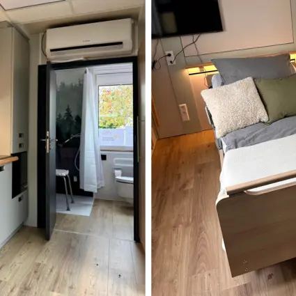 Innenansicht des TinyCareHome mit integrierter Küchenzeile, Badzugang und einem modernen Pflegebett von Stiegelmeyer im Wohnbereich. Das Bett steht auf warmem Holzfußboden und ist mit Kissen sowie indirekter Beleuchtung wohnlich gestaltet.