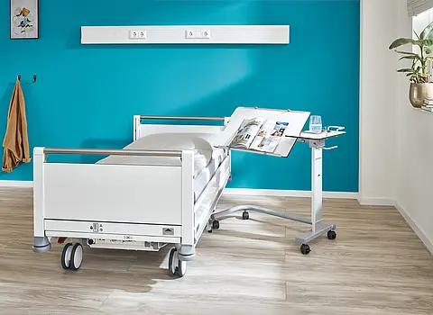Seta pro - variant junior children’s hospital bed with bedside table – Stiegelmeyer Modern Seta pro - variant junior children’s hospital bed with bedside table in a patient room